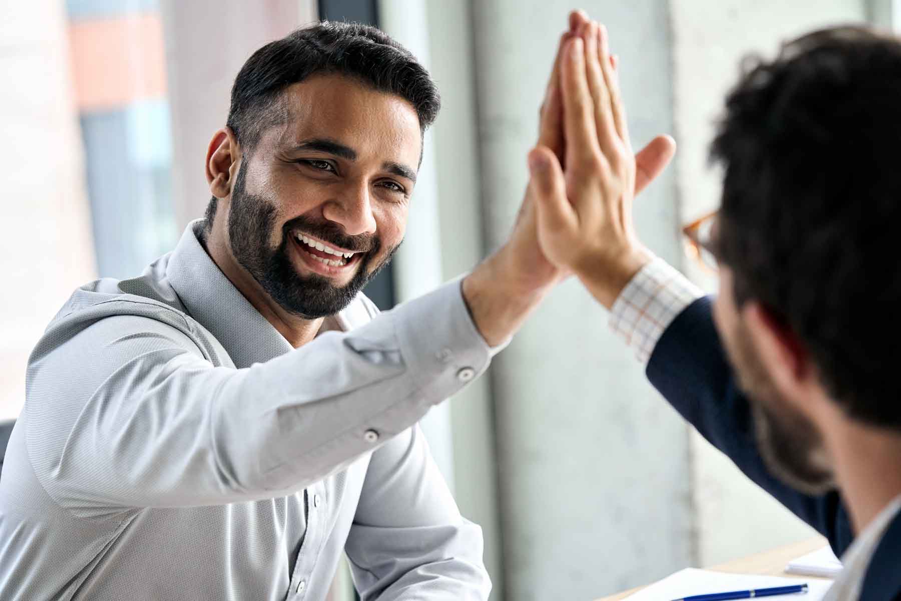 A life coach high-fiving a client to celebrate an achievement